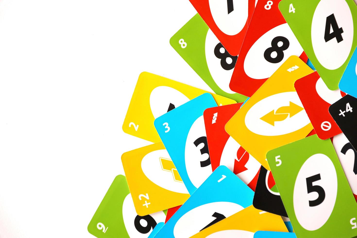 TERNOPIL, UKRAINE - MAY 15, 2022 Many colorful UNO game cards on white background. UNO is an American shedding-type card game that is played with a specially printed deck photo