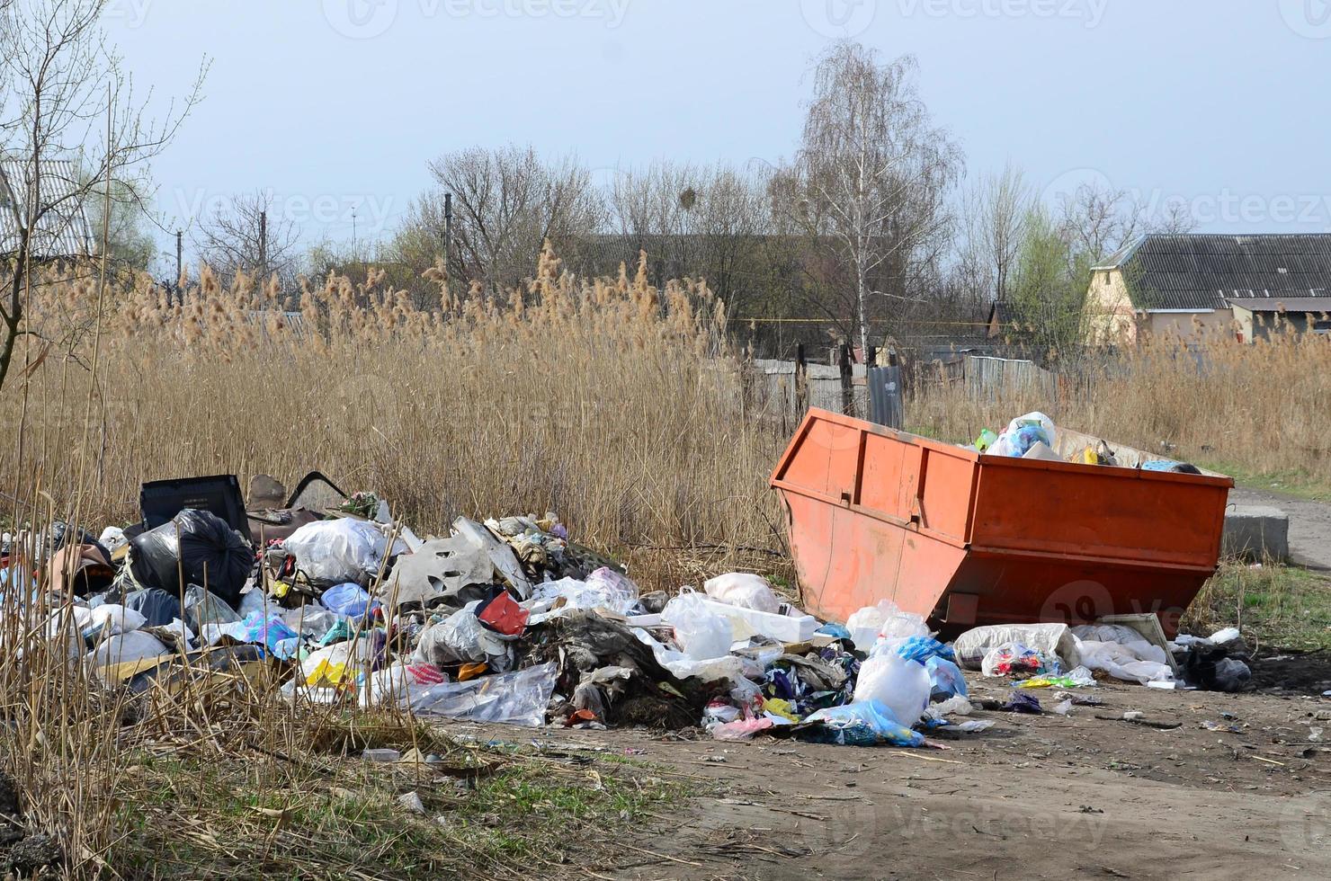 el bote de basura está lleno de basura y desechos. retiro intempestivo de basura en zonas pobladas foto