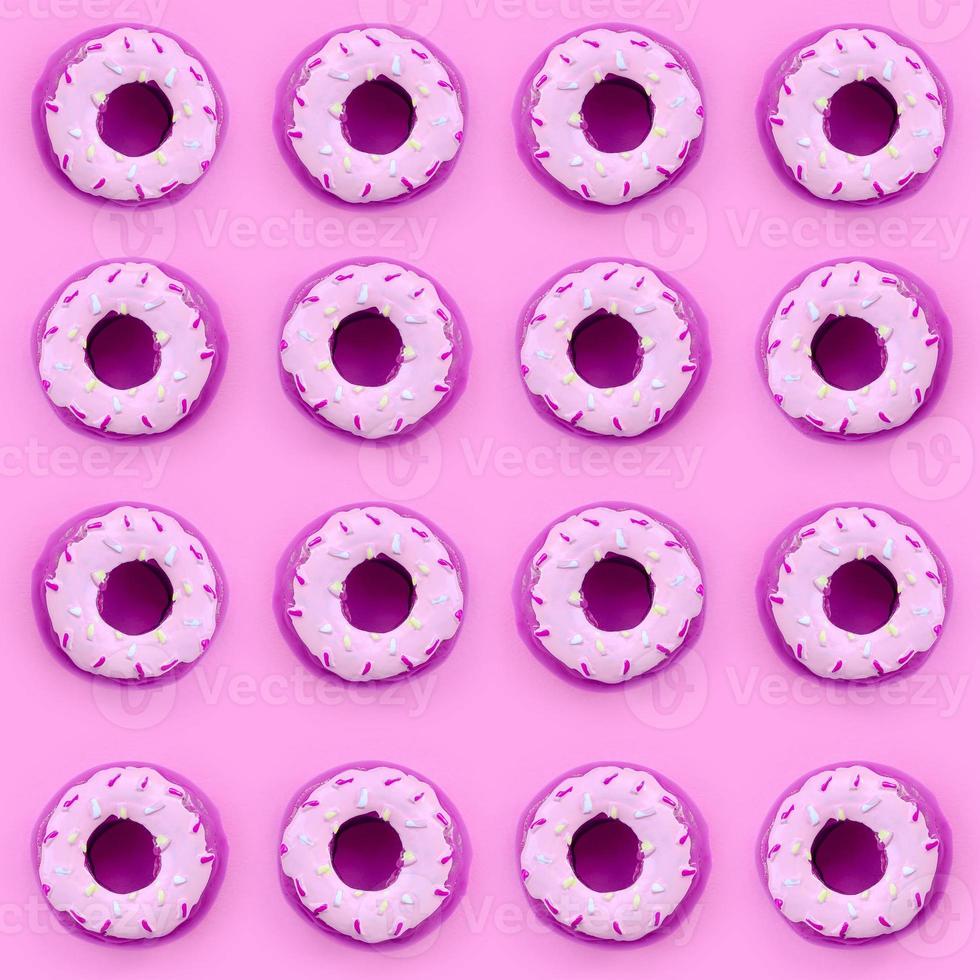 Many small plastic donuts lies on a pastel colorful background. Flat lay minimal pattern. Top view photo