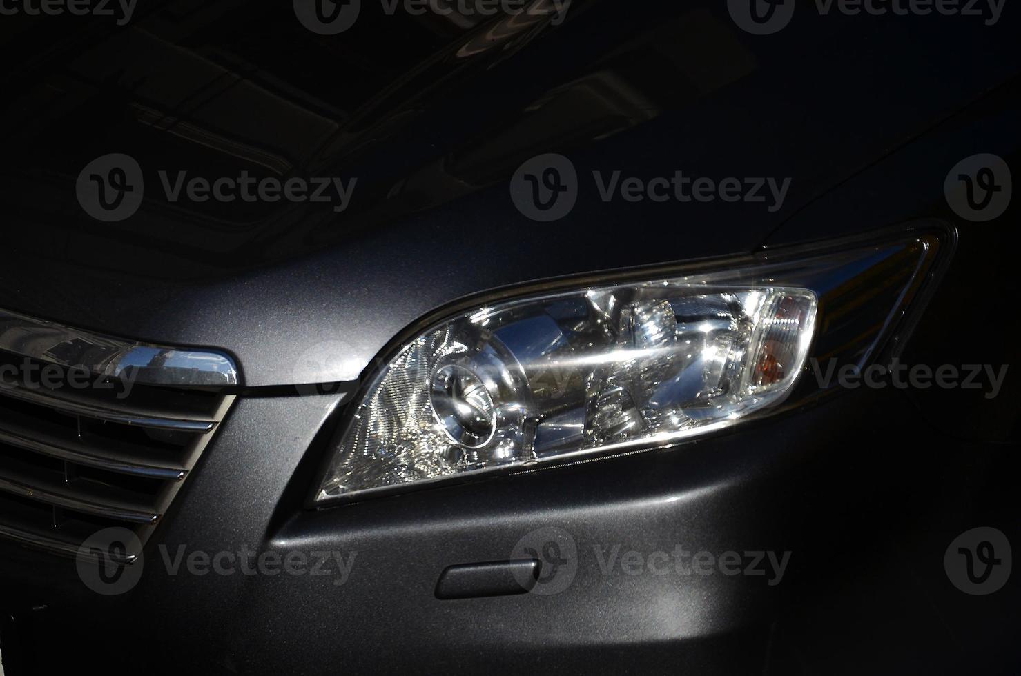 The headlight of the car is close-up. Fragment of the car body photo