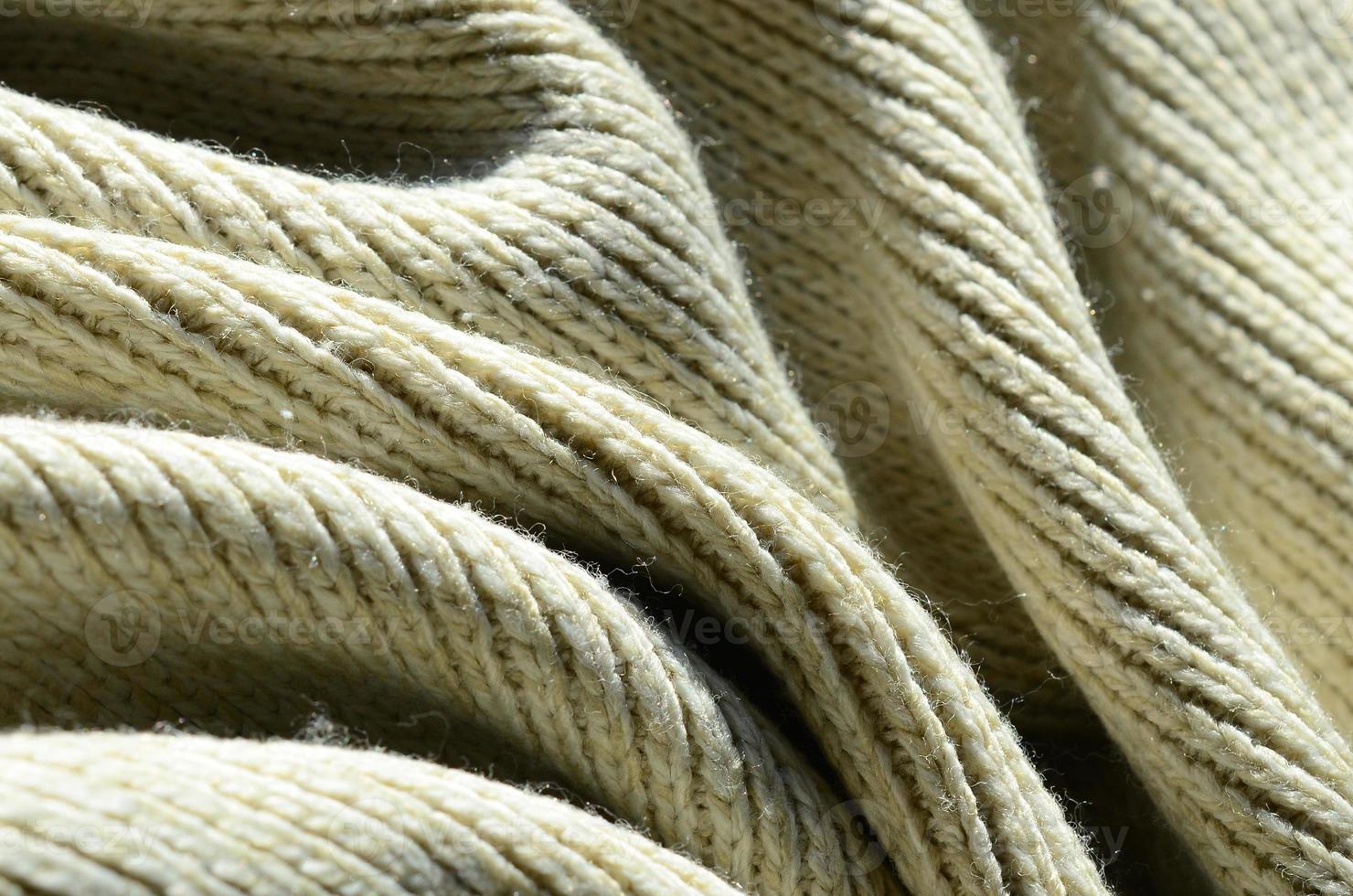 Fabric texture of a soft yellow knitted sweater. Macro image of the structure of bindings in yarns photo