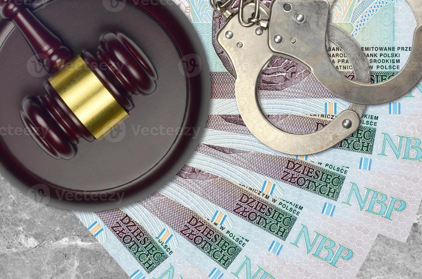 10 Polish zloty bills and judge hammer with police handcuffs on court desk. Concept of judicial trial or bribery. Tax avoidance photo