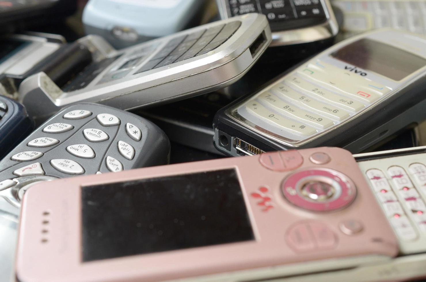 KHARKOV, UKRAINE - DECEMBER 9, 2020 Bunch of old used outdated mobile phones. Recycling electronics in the market cheap photo