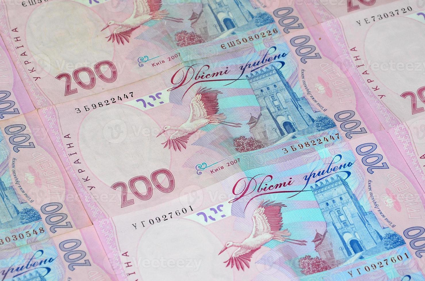 A close-up of a pattern of many Ukrainian currency banknotes with a par value of 200 hryvnia. Background image on business in Ukraine photo