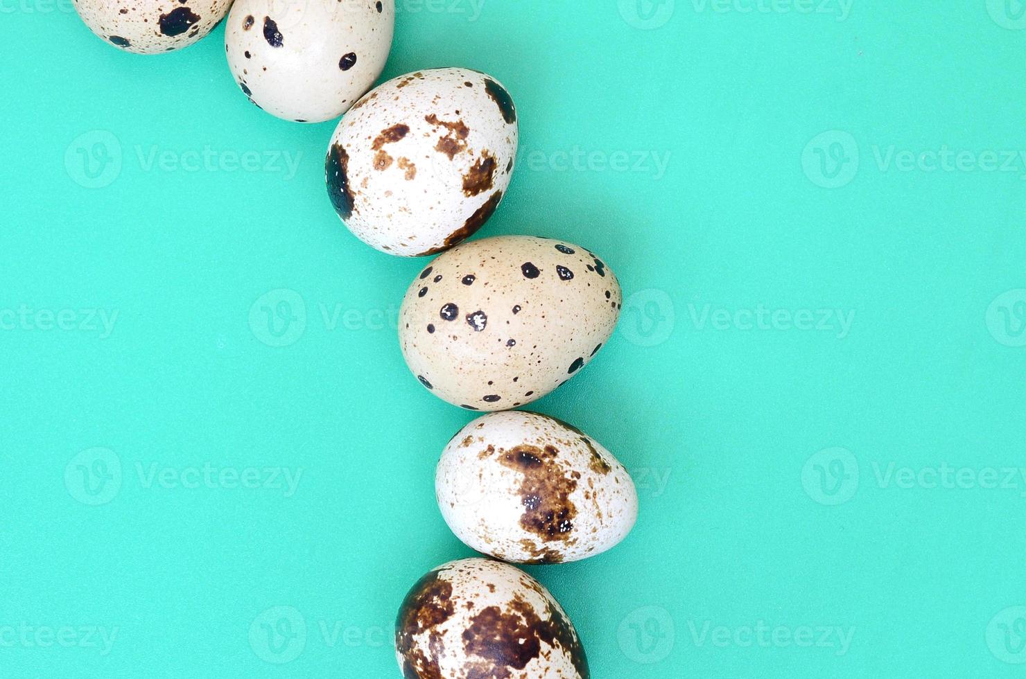 Quail eggs on a light green surface, top view, empty place for text, recipe photo