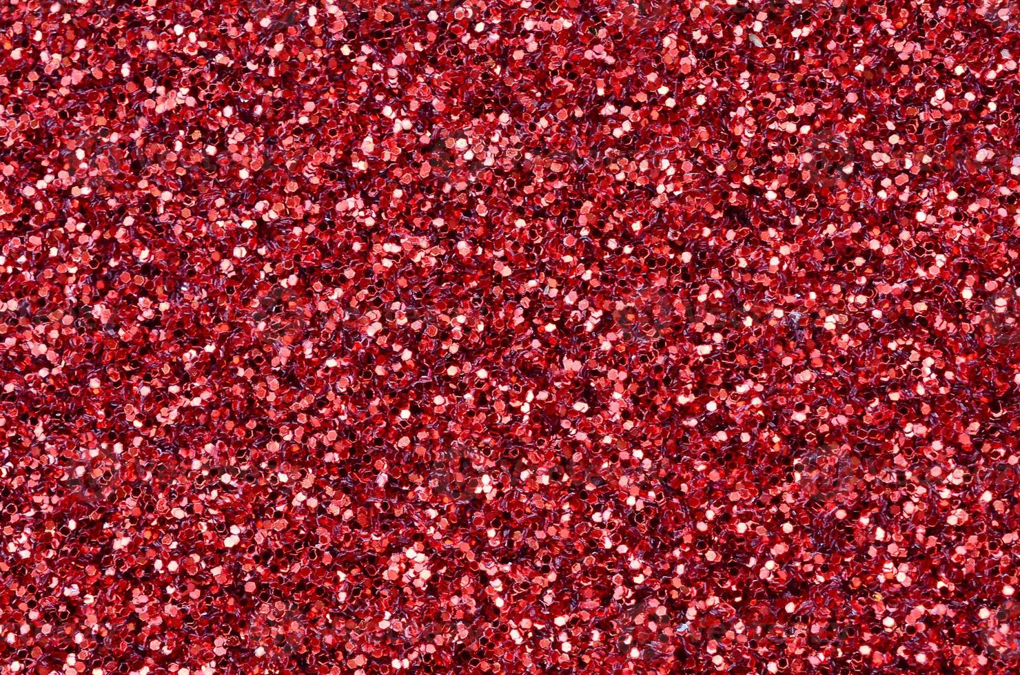 A huge amount of red decorative sequins. Background texture with shiny, small elements that reflect light in a random order. Glitter texture photo