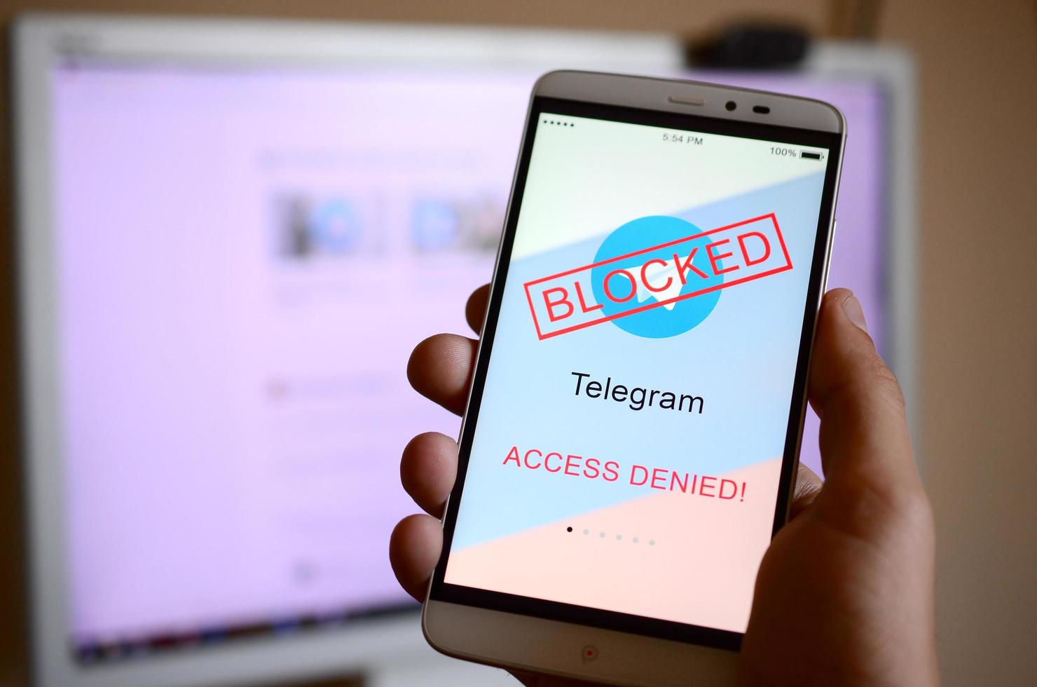 KHARKOV, UKRAINE - APRIL 30, 2018 A mobile phone with the Telegram app screen with a prohibiting sign and russian flag. Roskomnadzor blocked the Telegram service in Russia photo