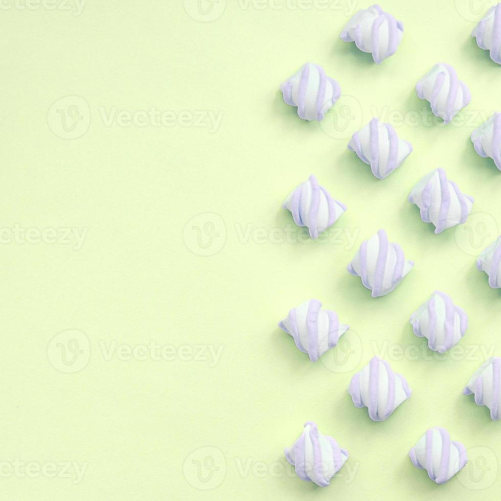 Colorful marshmallow laid out on lime paper background. pastel creative textures photo