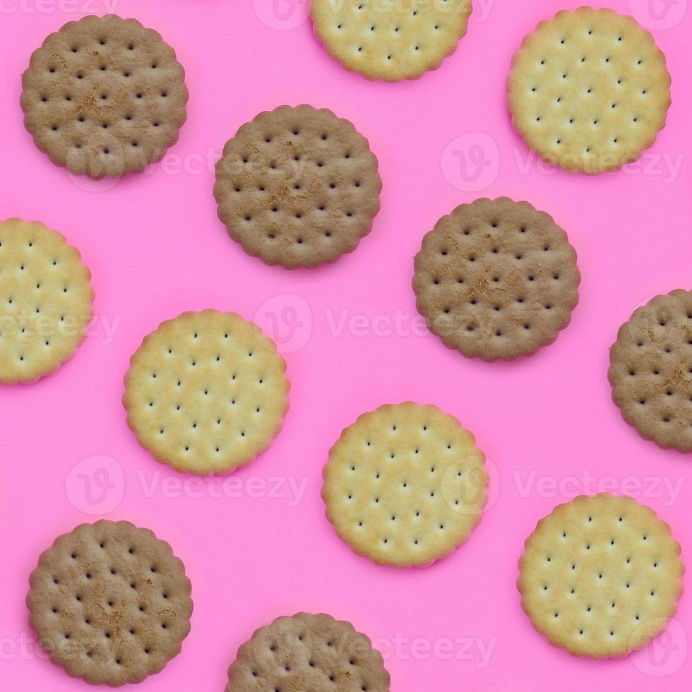 Pattern of a brown biscuits on a pink background. Trendy minimal concept of food and dessert. Abstract flat lay, top view photo