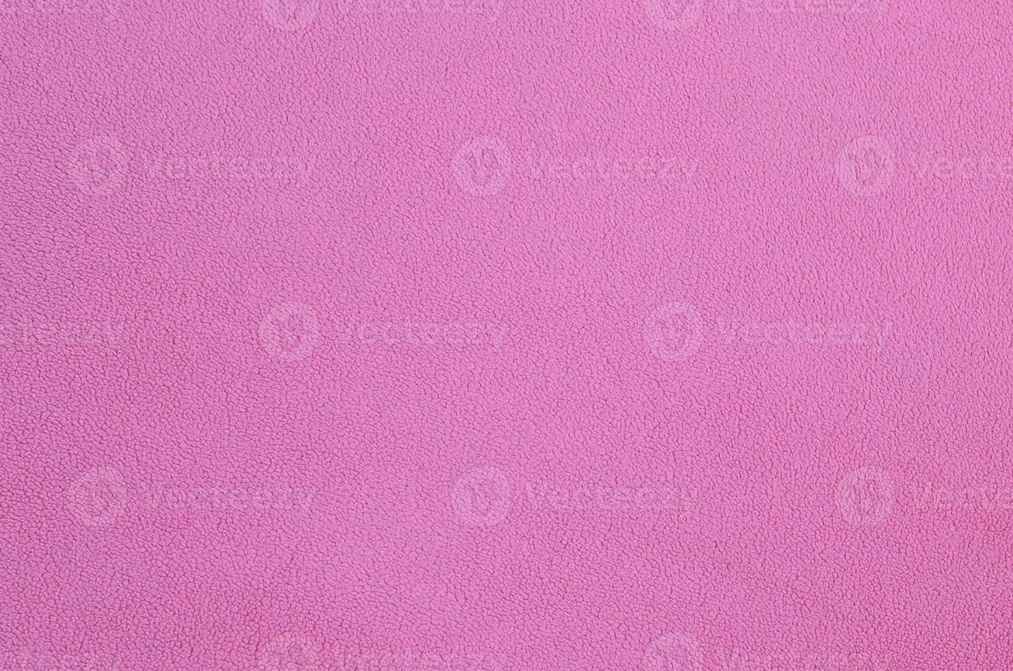 The blanket of furry pink fleece fabric. A background texture of light pink soft plush fleece material photo