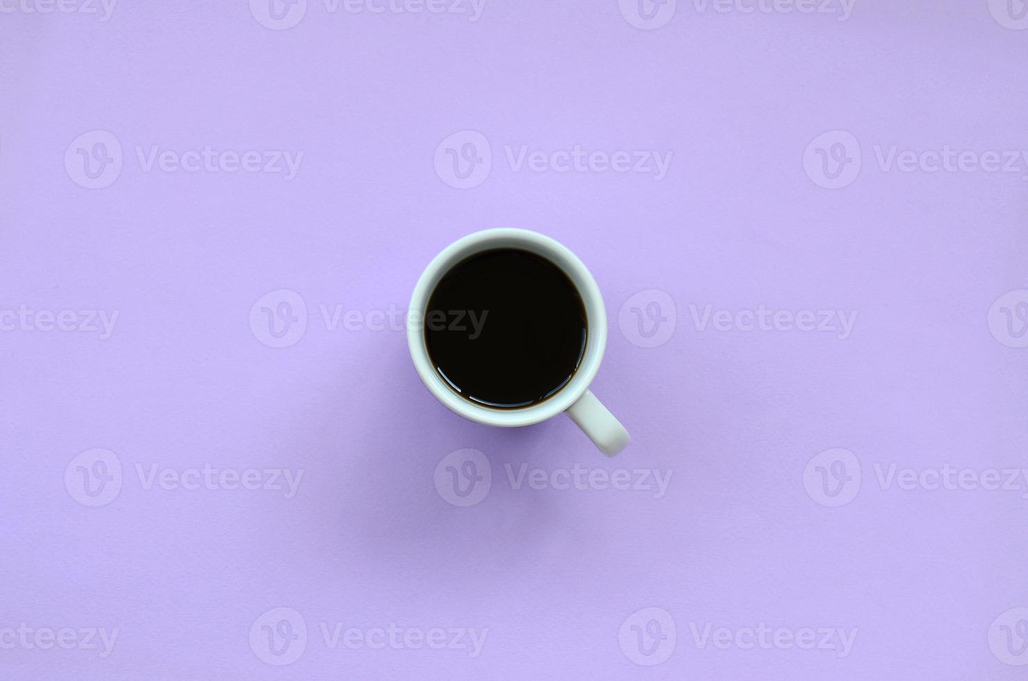Small white coffee cup on texture background of fashion pastel violet color paper in minimal concept photo