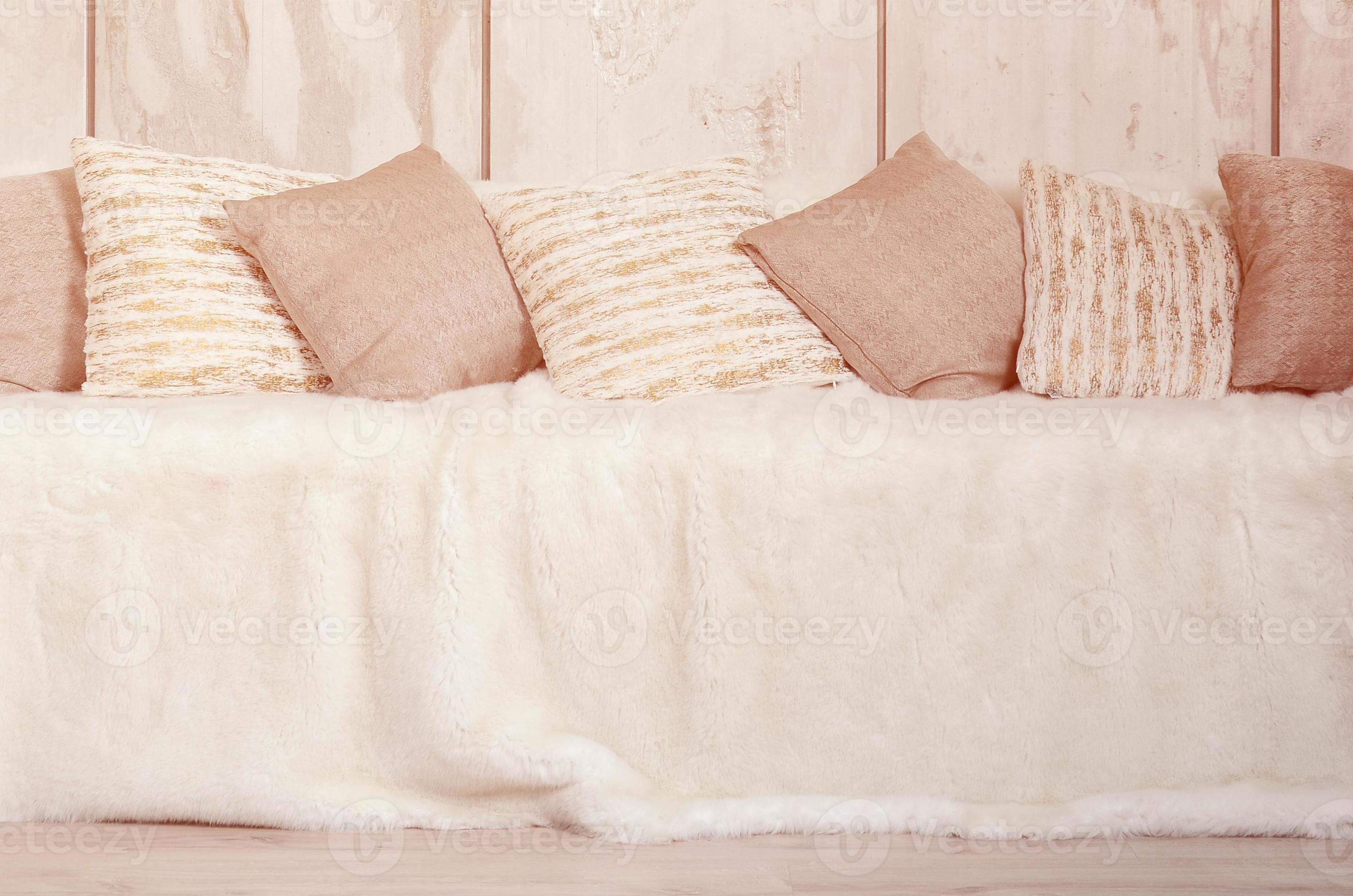 Many pillows lie on the couch, which is covered with a large plush veil