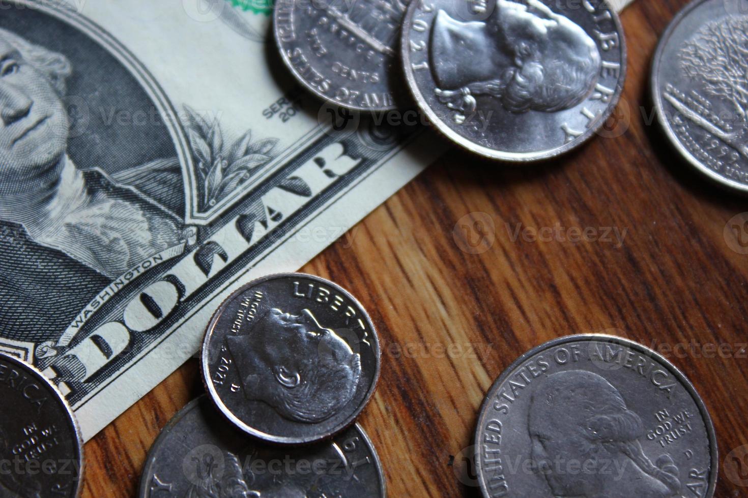 Dollar coins and dollar bills scattered on a wooden table, flat lay dollar coins. photo