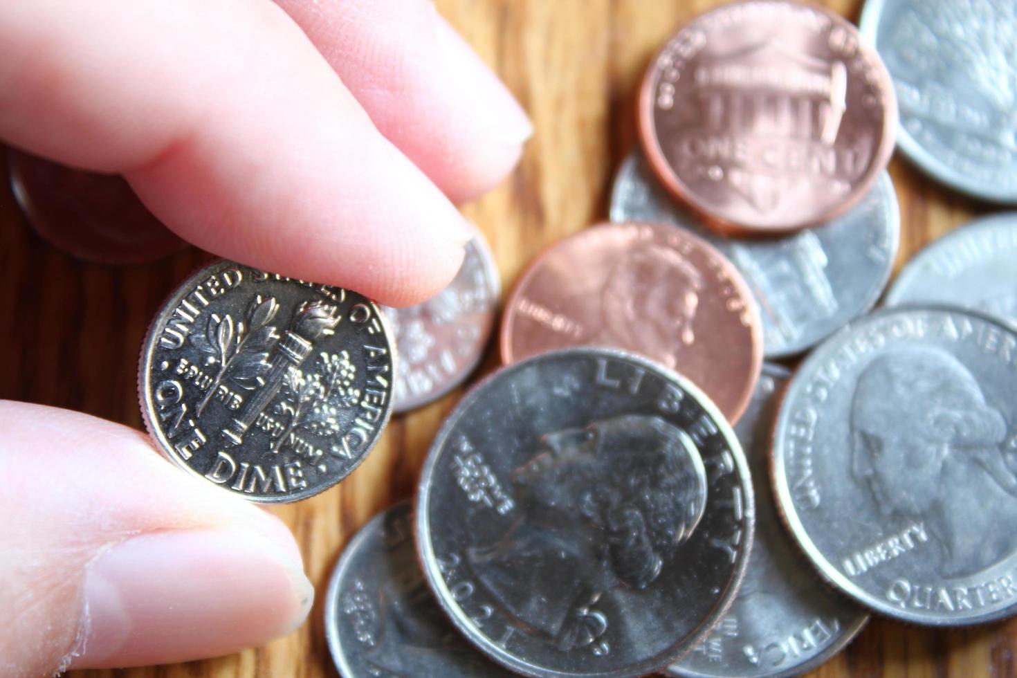 Dollar coins and dollar bills scattered on a wooden table, flat lay dollar coins. photo