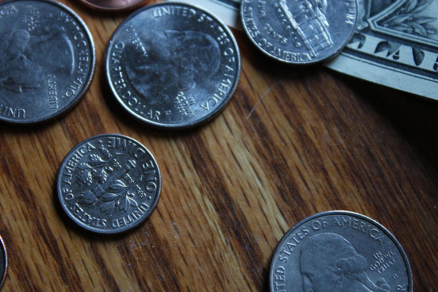 Dollar coins and dollar bills scattered on a wooden table, flat lay dollar coins. photo