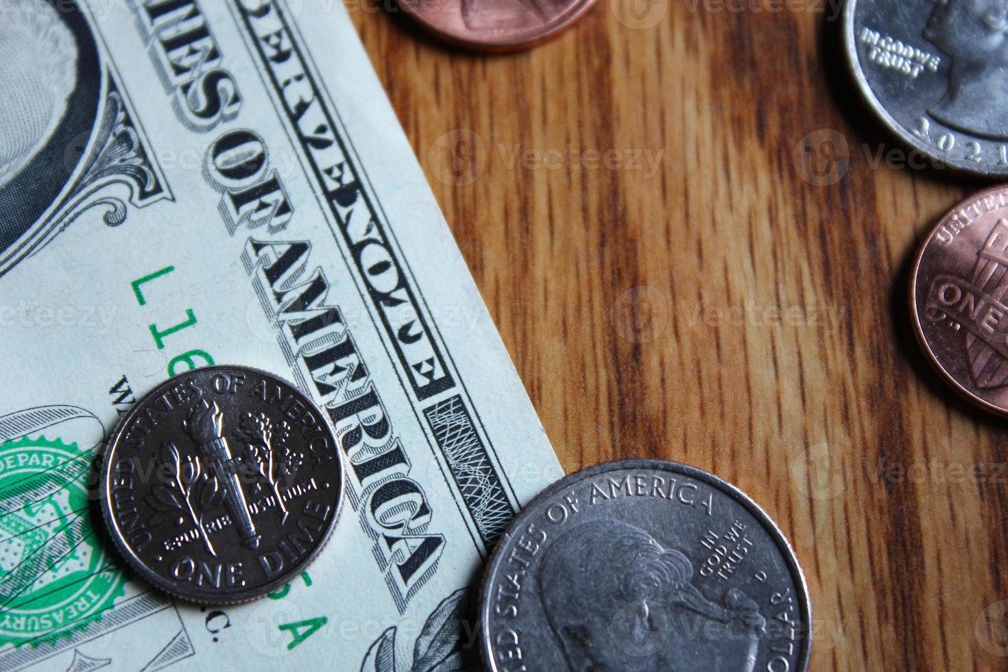 Dollar coins and dollar bills scattered on a wooden table, flat lay dollar coins. photo