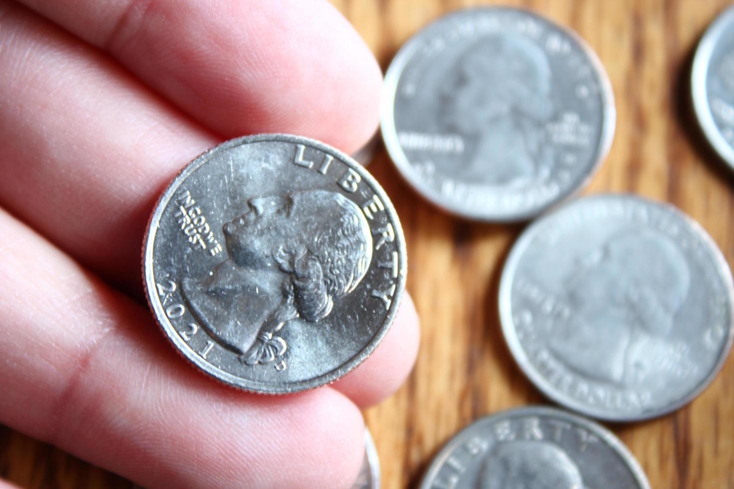 Dollar coins and dollar bills scattered on a wooden table, flat lay dollar coins. photo