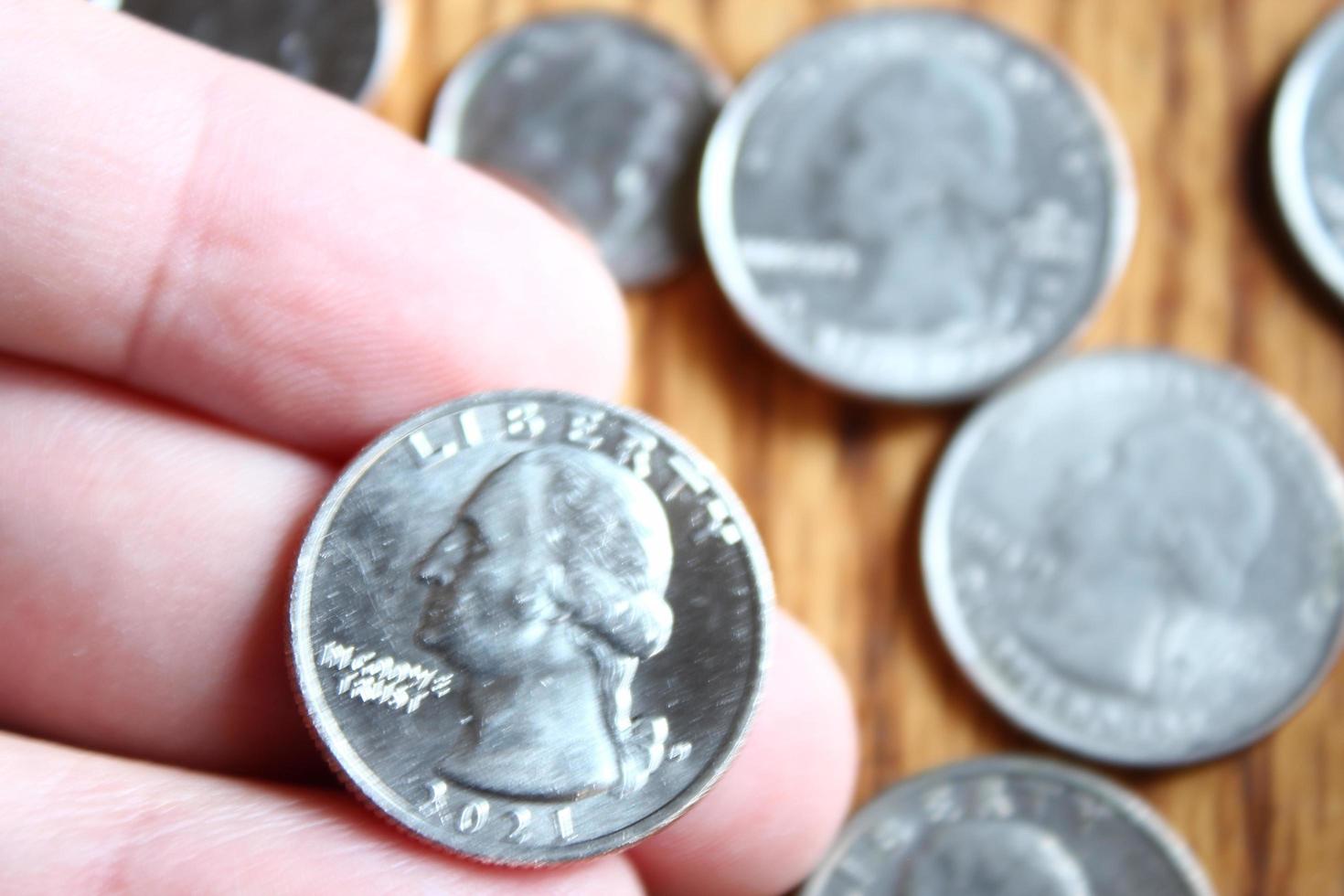 Dollar coins and dollar bills scattered on a wooden table, flat lay dollar coins. photo