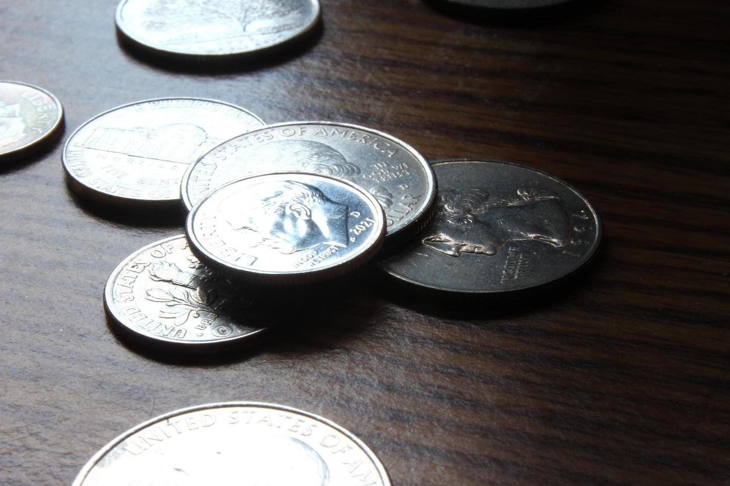 monedas de dólar esparcidas sobre una mesa de madera, foto