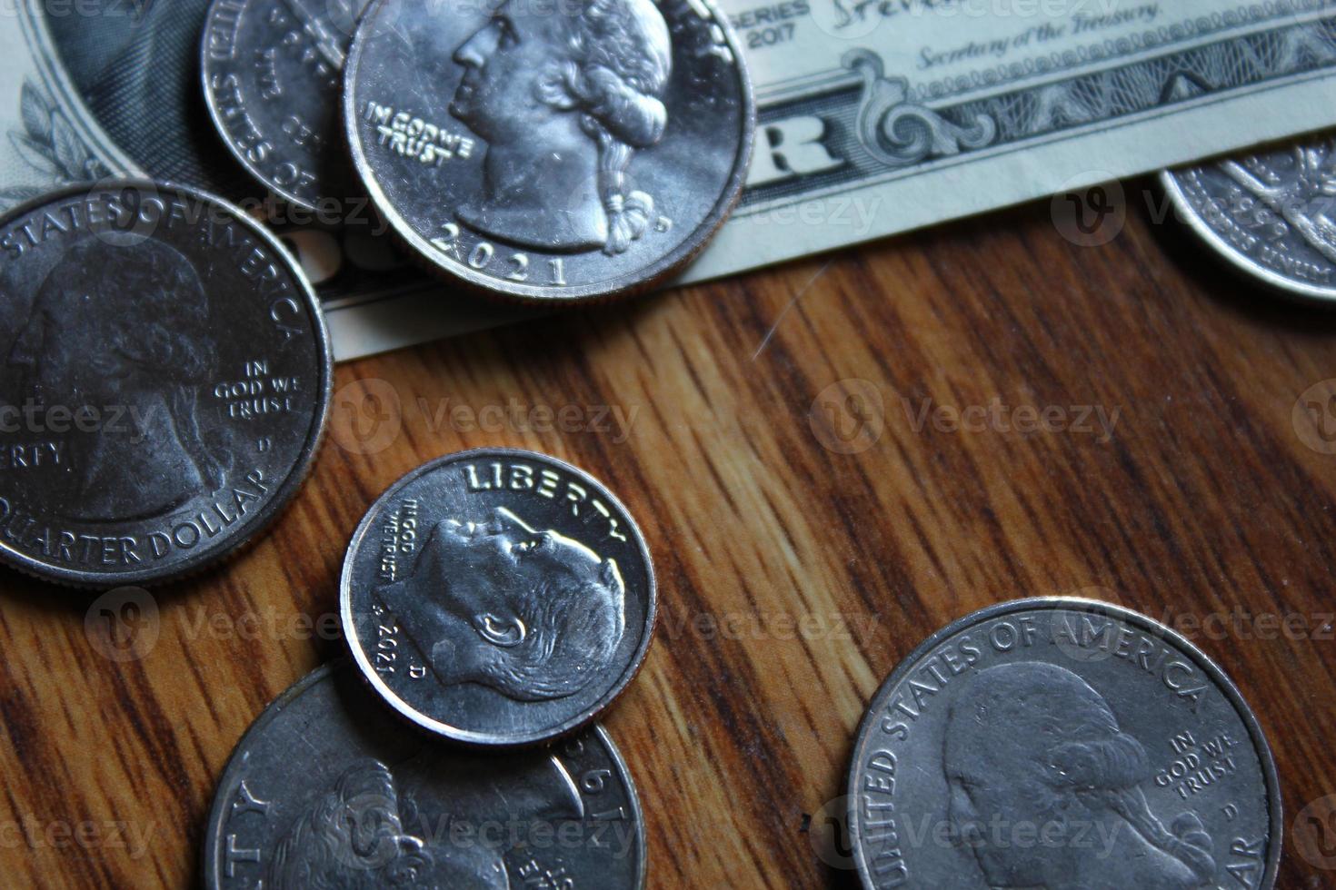 Dollar coins and dollar bills scattered on a wooden table, flat lay dollar coins. photo