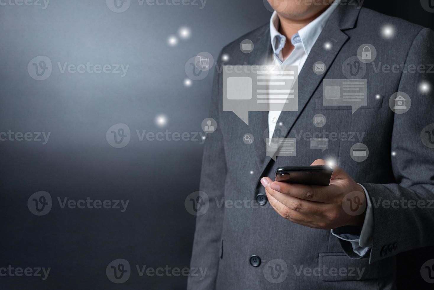 Close up businessman pushing, touching on smartphone with virtual emotion icon on black and gray background photo
