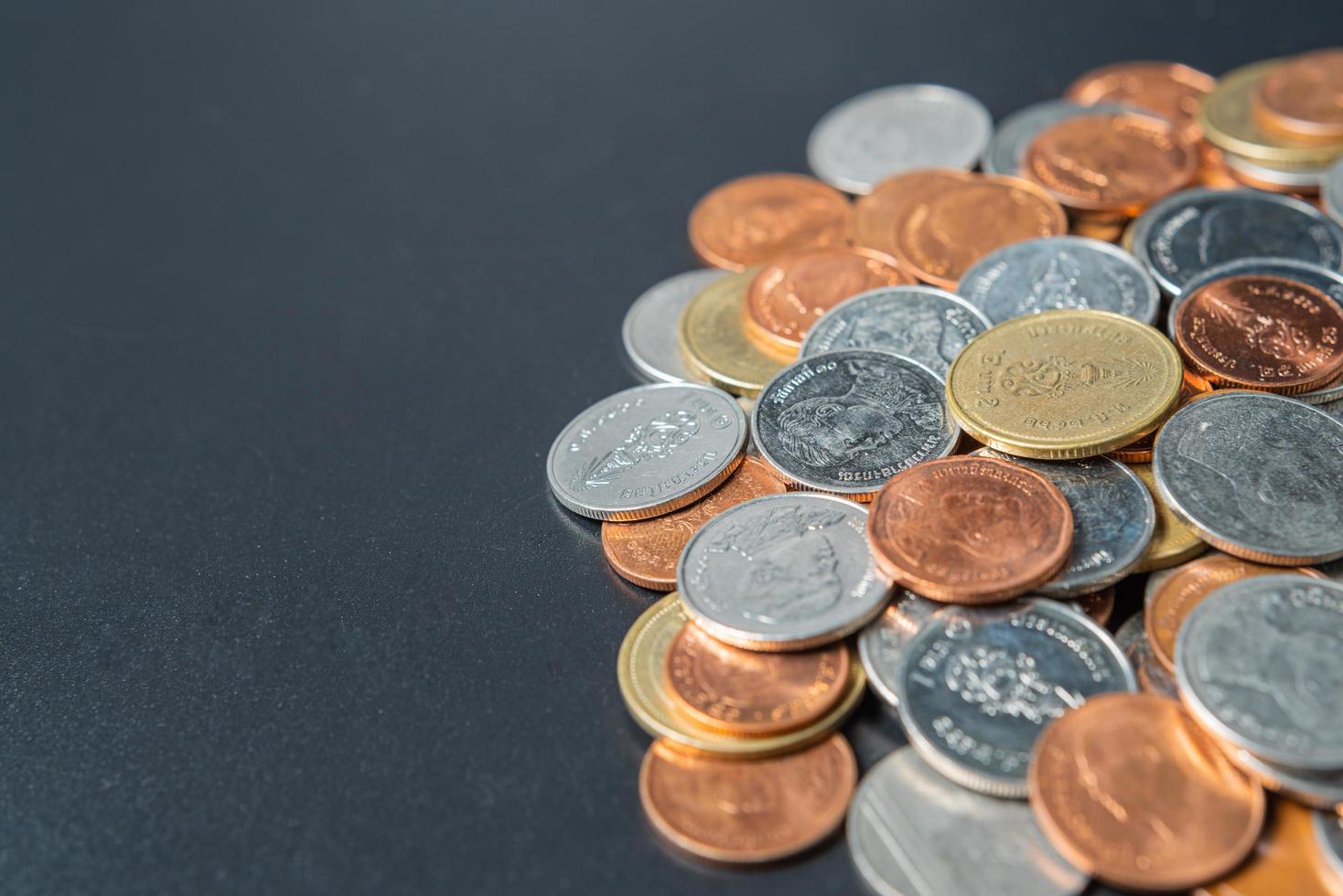 Heap coins on black table with space. photo