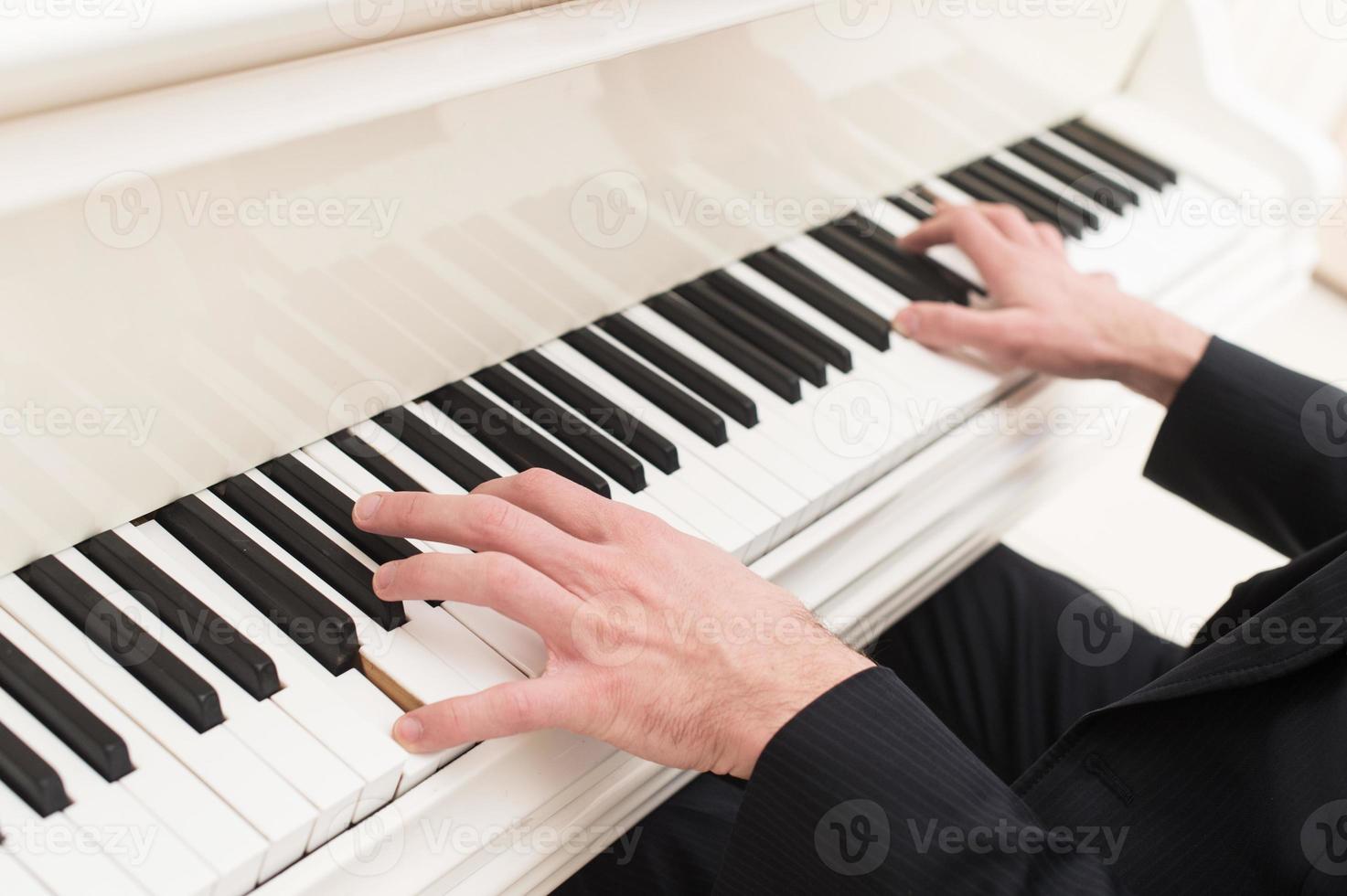Playing piano. Close-up top view of man playing piano photo