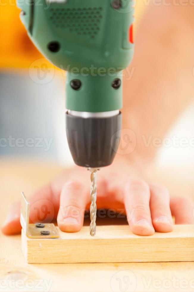 Drilling work. Close-up of man using drill in workshop photo