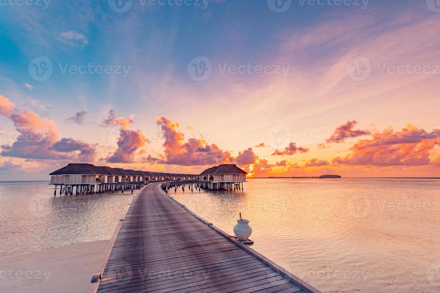 Amazing beach landscape. Beautiful Maldives sunset seascape view. Horizon colorful sea sky clouds, over water villa pier pathway. Tranquil island lagoon, tourism travel background. Exotic vacation photo