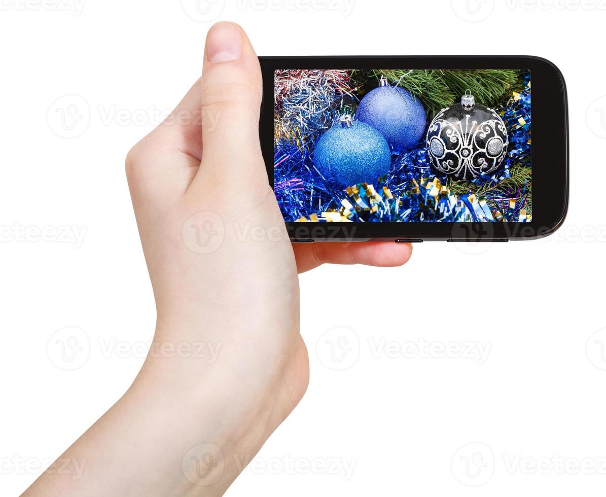 hand holds cellphone with Xmas decorations photo