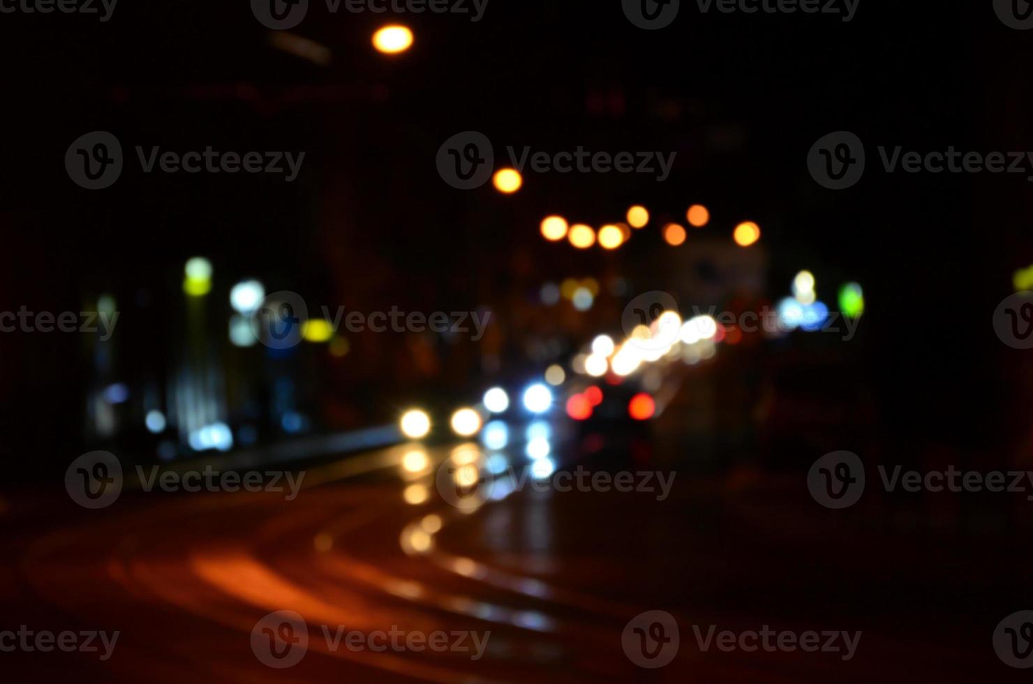 escena nocturna borrosa de tráfico en la carretera. imagen desenfocada de coches que viajan con faros luminosos. arte bokeh foto