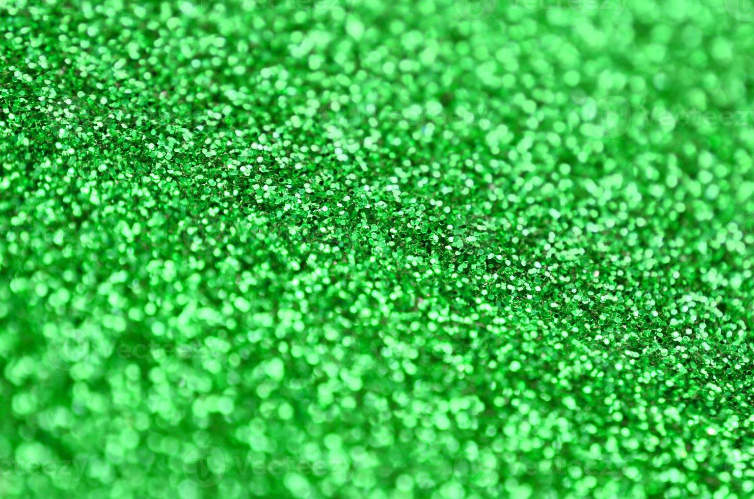 una gran cantidad de lentejuelas decorativas verdes. imagen de fondo con luces bokeh brillantes de elementos pequeños foto