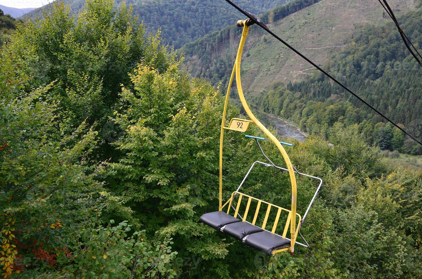 The seats of the cable car on the background of Mount Makovitsa, one of the Carpathian Mountains photo