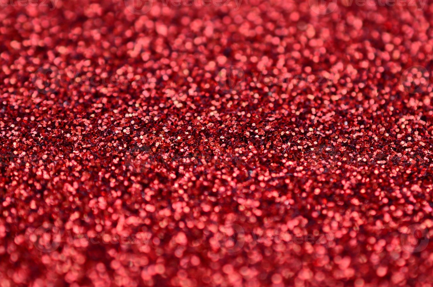 A huge amount of red decorative sequins. Background texture with shiny, small elements that reflect light in a random order. Glitter texture photo