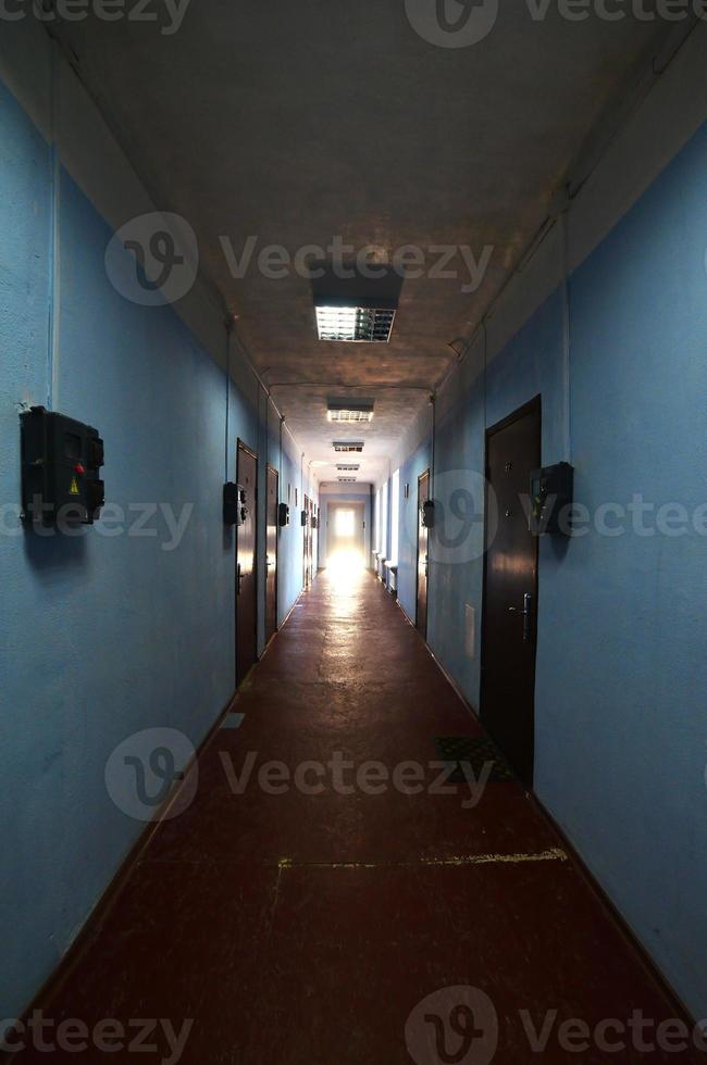 el lúgubre pasillo de un edificio público abandonado. espacio público en un edificio alto residencial pobre foto