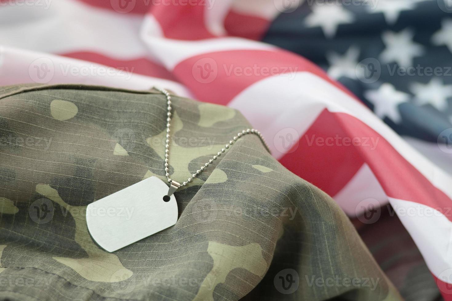 Cuentas militares plateadas con etiqueta de perro en la bandera de tela de los Estados Unidos y uniforme de camuflaje foto