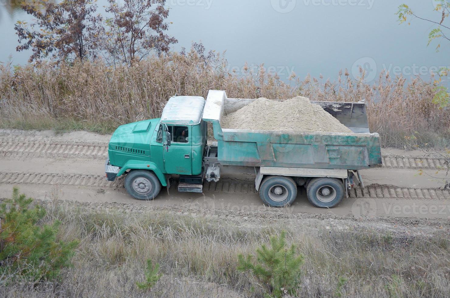 Dump truck transports sand and other minerals in the mining quarry. Heavy industry photo