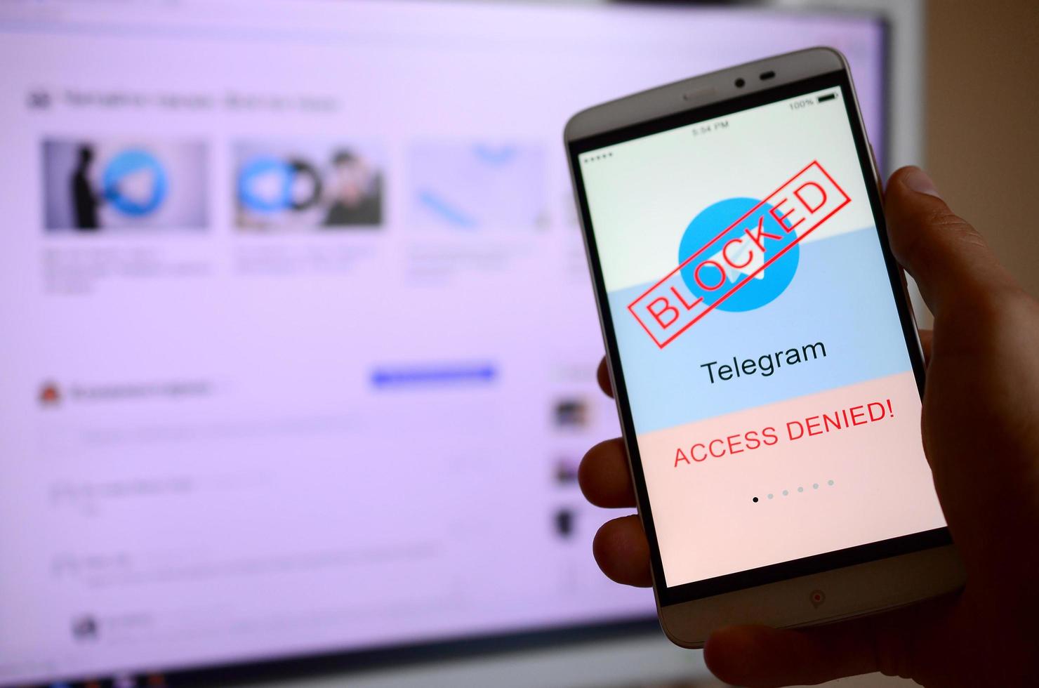 KHARKOV, UKRAINE - APRIL 30, 2018 A mobile phone with the Telegram app screen with a prohibiting sign and russian flag. Roskomnadzor blocked the Telegram service in Russia photo