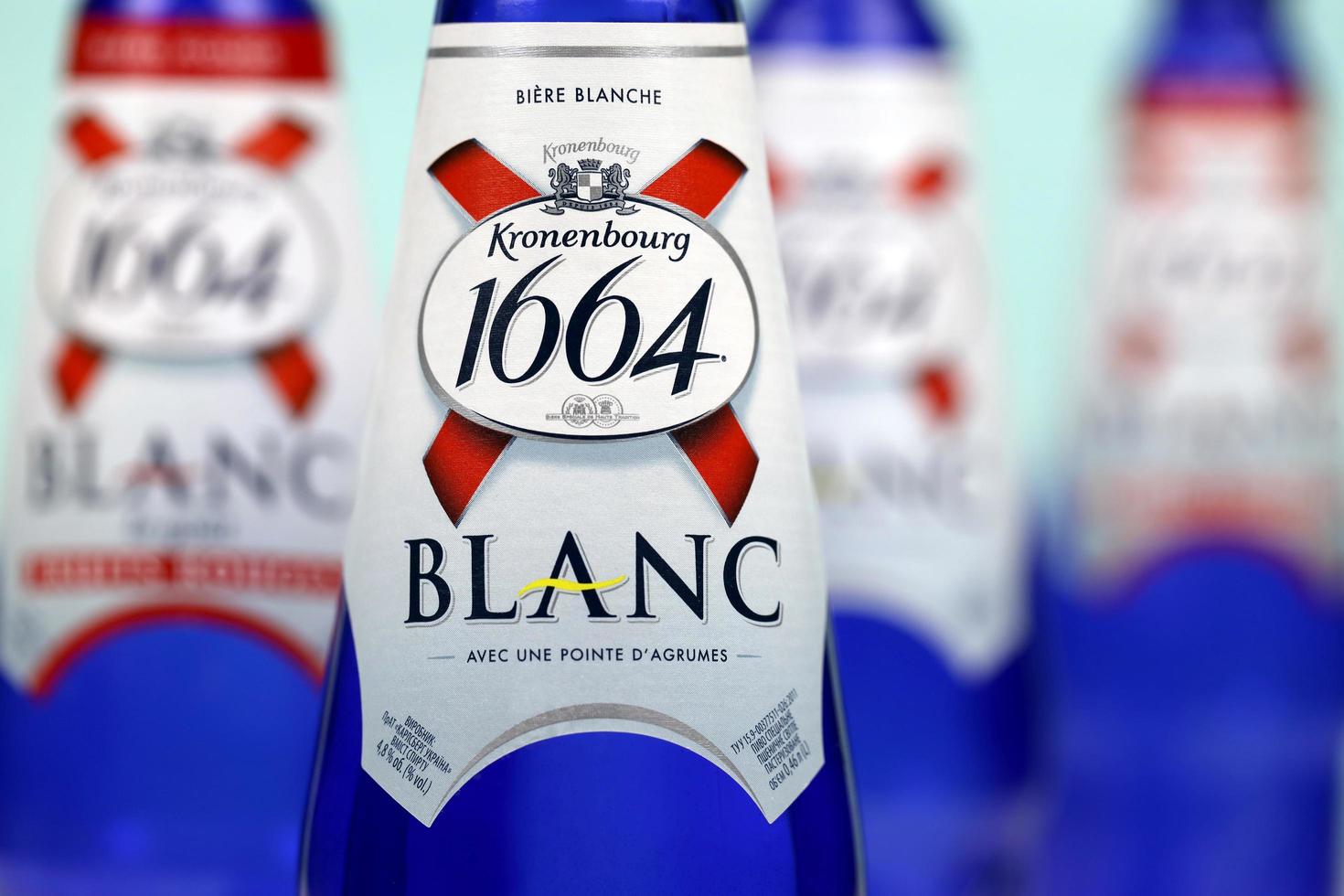 KHARKOV, UKRAINE - DECEMBER 8, 2020 Blanc logo on beer bottles on white table. 1664 Blanc is the wheat beer from French brewery Kronenbourg exported worldwide photo