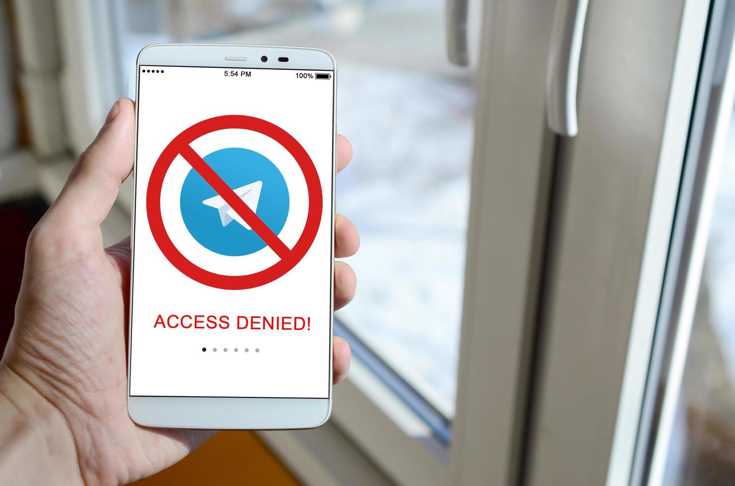 KHARKOV, UKRAINE - APRIL 27, 2018 A mobile phone with the Telegram app screen with a prohibiting sign. Roskomnadzor blocked the Telegram service in Russia. Access to telegram messenger is closed photo