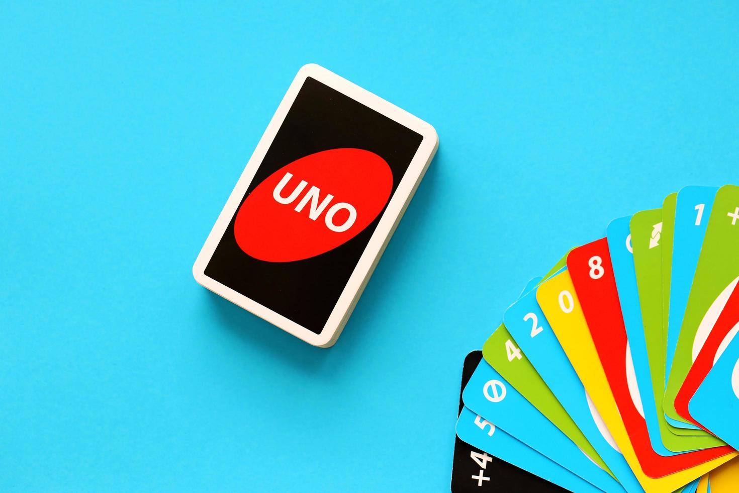 TERNOPIL, UKRAINE - MAY 15, 2022 Many colorful UNO game cards on blue background. UNO is an American shedding-type card game that is played with a specially printed deck photo