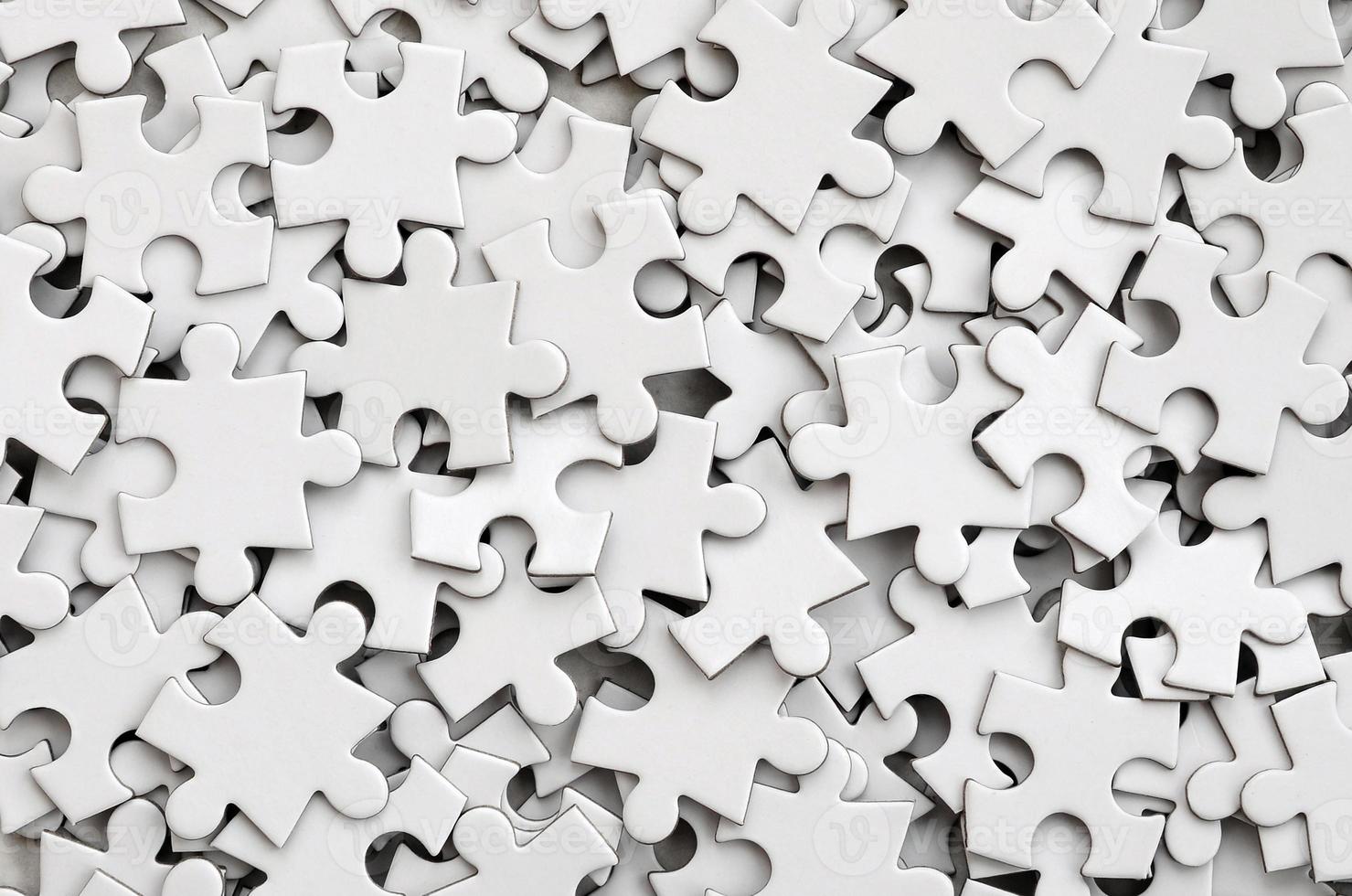Close-up of a pile of uncompleted elements of a white puzzle. A huge number of rectangular pieces from one large white mosaic photo