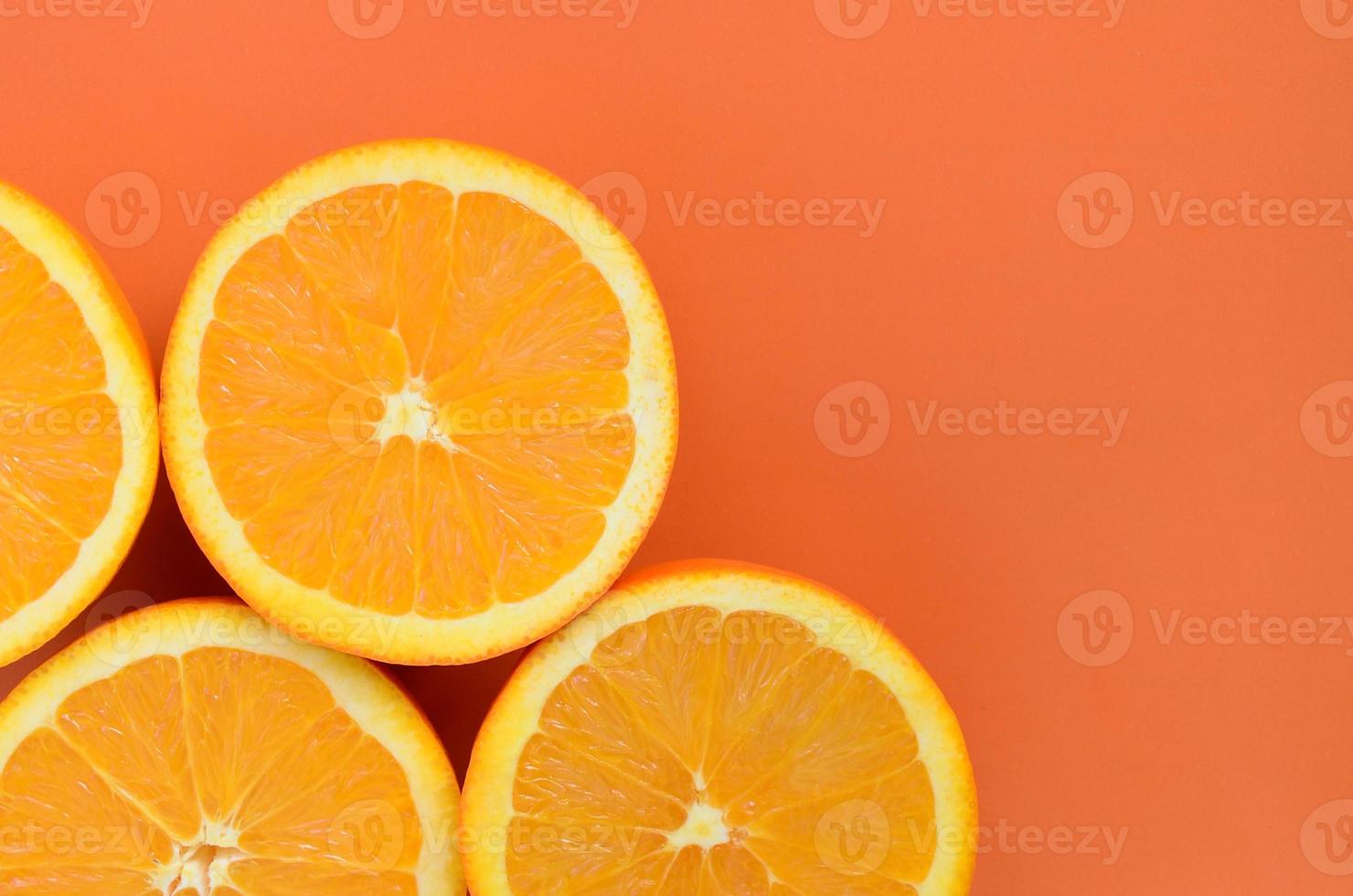 Top view of a several orange fruit slices on bright background in orange color. A saturated citrus texture image photo