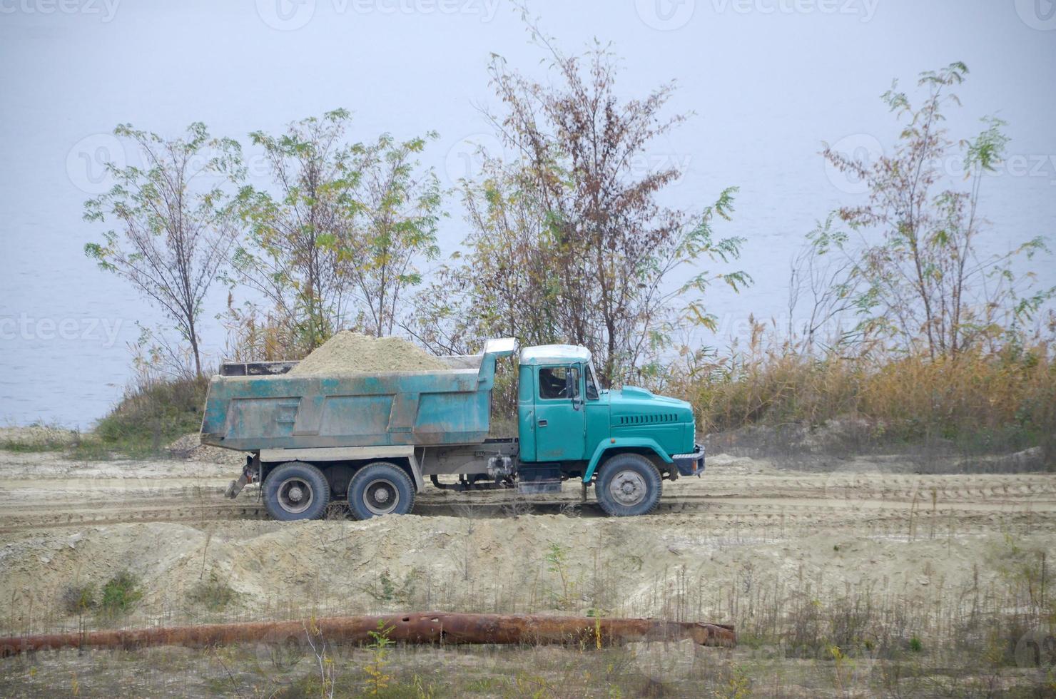 Dump truck transports sand and other minerals in the mining quarry. Heavy industry photo