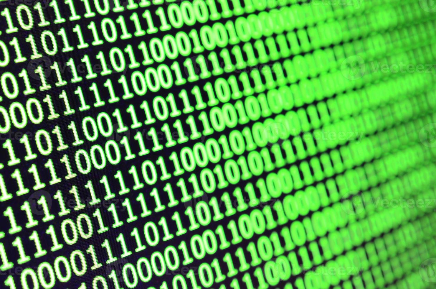 Macro shot of binary code on the monitor of an office computer. The concept of the programmer's work. The flow of digital information strings photo