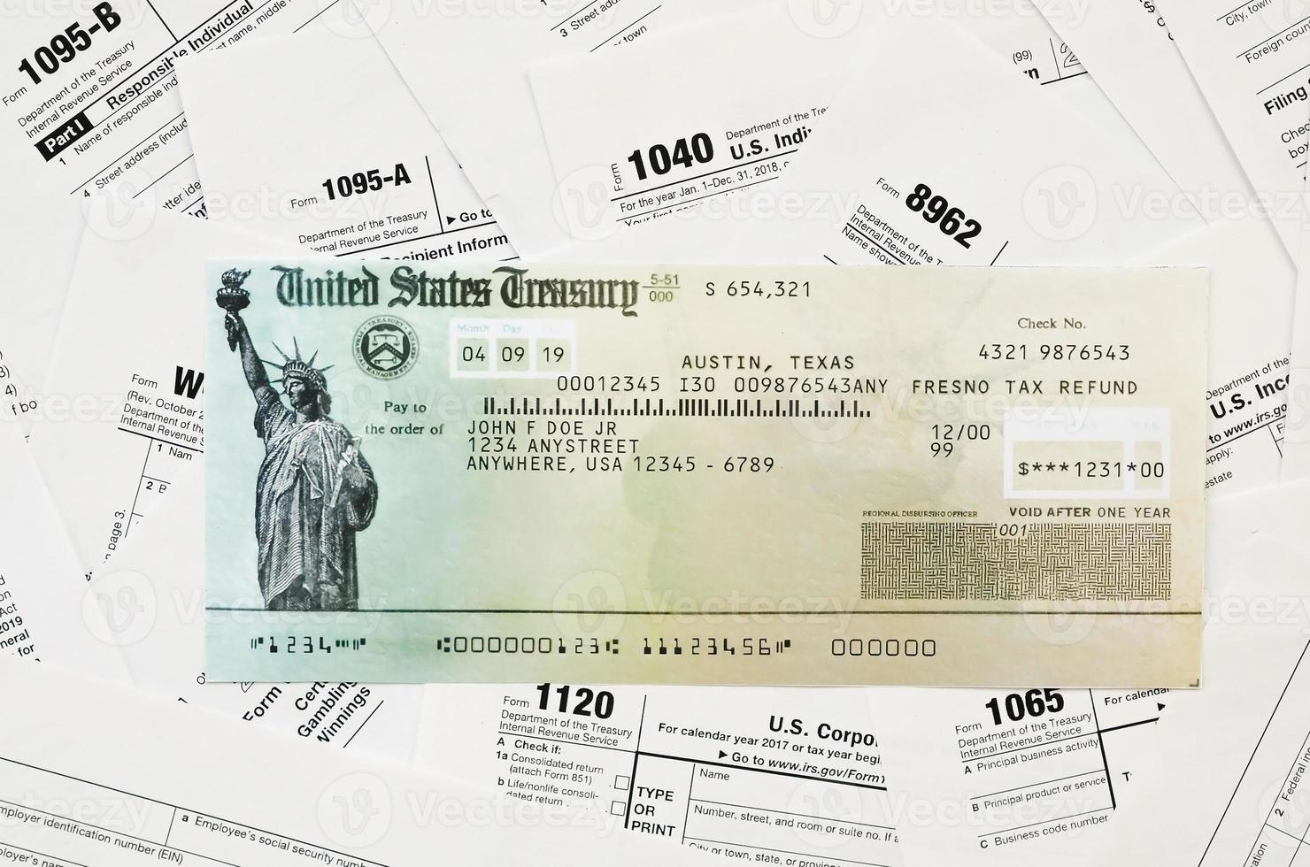Refund check on many tax form blanks lies on table close up. Tax payers paperwork routine and bureaucracy concept photo