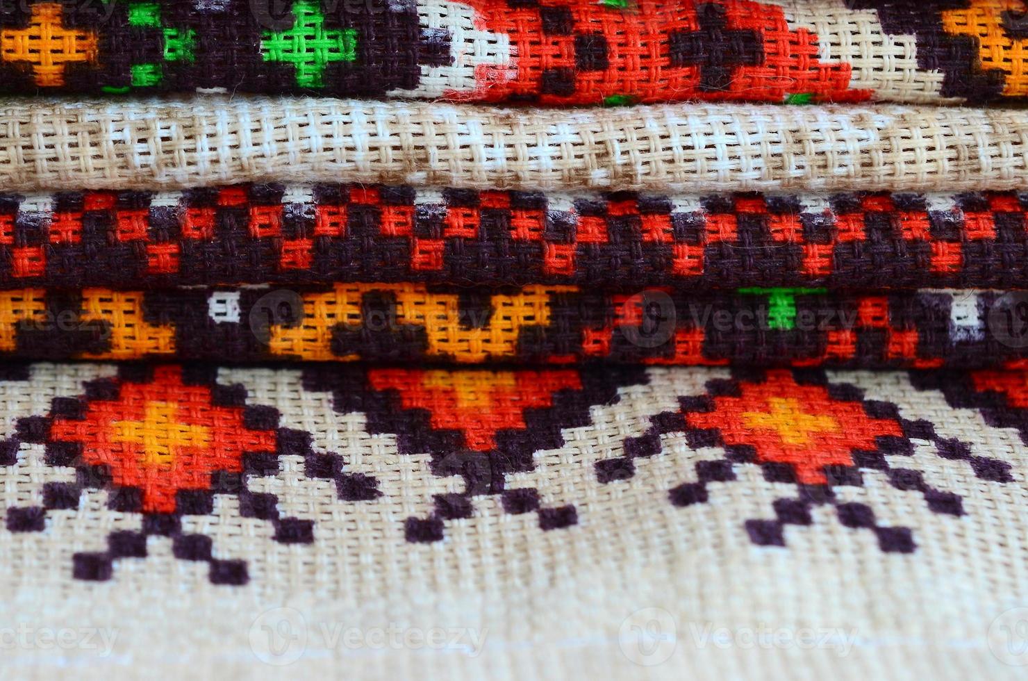 Stack of traditional Ukrainian folk art knitted embroidery patterns on textile fabric photo
