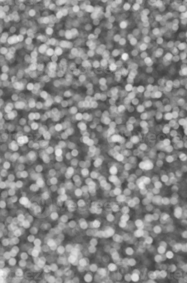 Blurred silver decorative sequins. Background image with shiny bokeh lights from small elements photo