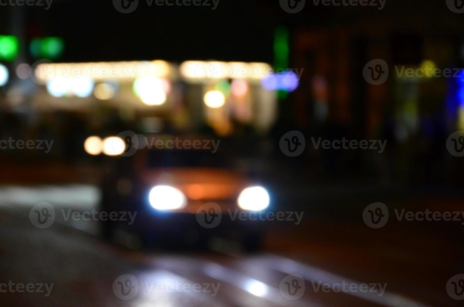 escena nocturna borrosa de tráfico en la carretera. imagen desenfocada de coches que viajan con faros luminosos. arte bokeh foto