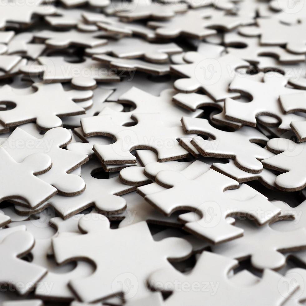 Close-up of a pile of uncompleted elements of a white puzzle. A huge number of rectangular pieces from one large white mosaic photo